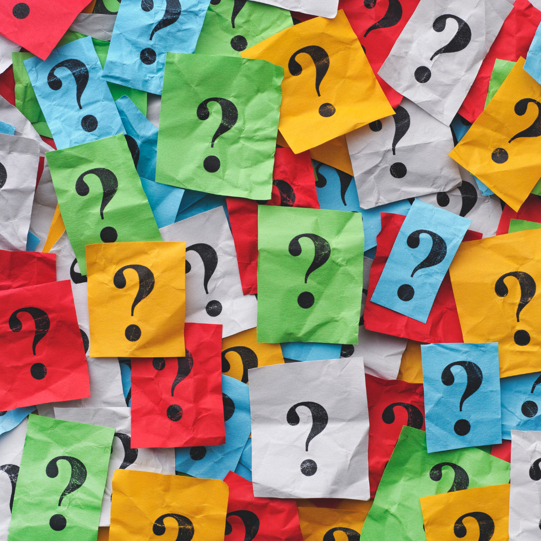 A pile of pieces of multicolor paper all showing a single question mark.